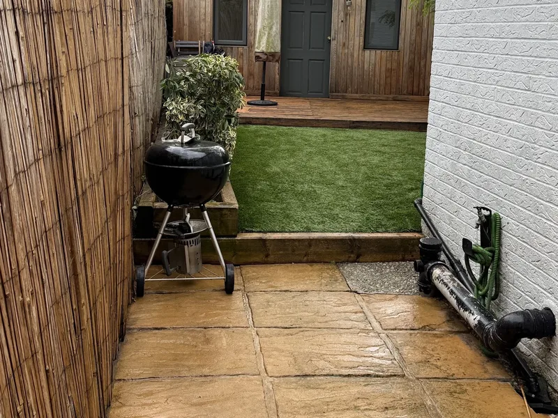 A finished side patio and lawn, the slabs freshly cleaned
